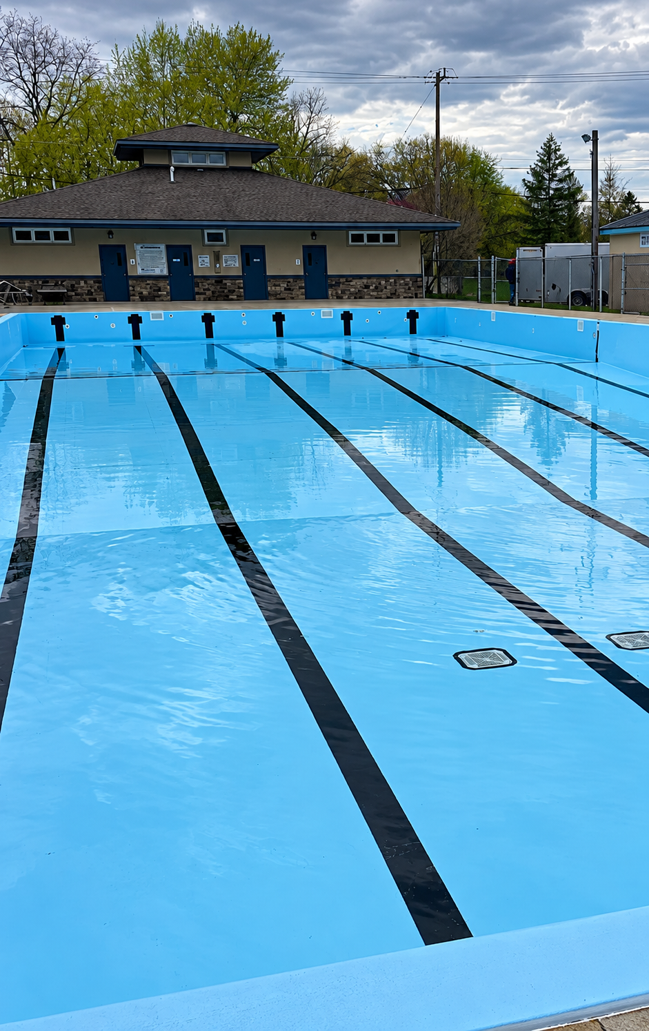 Outdoor swimming pool with marked lanes and facility building